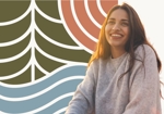 Smiling woman in a gray sweater beside the Mid Valley forest, sun and river pattern